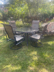53” glass top charcoal finish patio table and four sling chairs