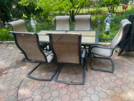 Dark bronze tile top patio table with six sling chairs