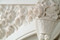 Beautiful floral basket is featured at the to of this arched marble mantel