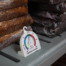 Thermometer positioned inside fridge, indicating current temperature