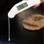 Thermometer in use measuring surface temperature on a grill