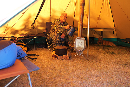 Hunter inside tent enjoying tent stove