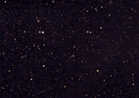 Deep 'jet black' background, with charcoal flecks, and occasional pintpoints of a reflective gold tone