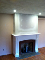 During this fireplace mantel remodel, brick was covered with sheet rock