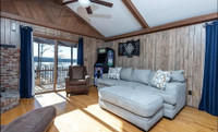 The after image features vintage, cabin-style vertical Swampland Cypress wood paneling, characteristic of mid-to-late 20th-century residential interiors.