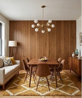 A warm and inviting Mid-Century Modern dining and living space that beautifully demonstrates how extensive Spirit Birch wood paneling can integrate open-concept functional zones. The room relies on a palette of rich wood tones, earthy mustard accents, and clean, iconic retro lines to create a cohesive, curated environment.
