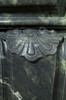 The Fontaine marble mantel legs are capped with a decorative emblem