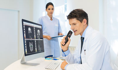 Doctor at desk with SpeechMike Premium Air using AirBridge