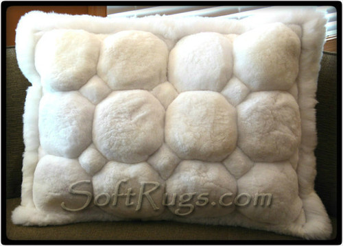 Alpaca Throw Pillow with White Puffs. This pillow features octogonal accents and has a white border.
