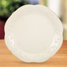 This dinner plate is distinguished by a white-on-white beaded motif. A tea-stain distressed finish around the plate's beaded edge adds just the right touch of color.