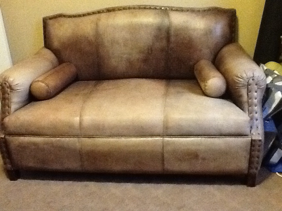  A photo of a vintage brown leather couch with the search query 'Indonesian heirloom artifacts'.