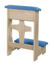 A blue kneeling pad connected to a wooden, rectangular shelf with a wooden cross between the legs that hold the shelf up.