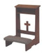 Rectangular wooden structure with a gray kneeling pad and small wooden cross as part of the structure.