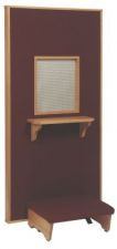 Tall wooden door-like structure with a mesh covering over a small window, a shelf below the window, and a padded kneeling space at the bottom.


