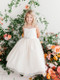  Girls white communion dress with rhinestone belt and tulle skirt. This beautiful communion dress features a V-neck style paired with a glittery tulle skirt and removable brooch. Order your First Communion dress today from St. Jude’s Shop!
Glitter Tulle Skirt
V-Neck Style
Removable Rhinestone Brooch
Center Zipper
Sash Tie-back 
Create a First Communion look as sweet and sparkly as your little girl. A V-shaped neckline crosses the sleeveless bodice creating that perfect a-line shape. With a sparkly tulle skirt and elegant brooch, your girl will feel extra special during this momentous occasion. 
Ankle Length 
Made in the U.S.A. 
3 Dress Limit Per Order