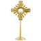 Gold plated monstrance with a golden sun in front of a golden cross 