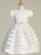 This unique and simple Communion dress offers a stunning look. Your daughter or granddaughter will love this gorgeous dress! It features a satin trimmed skirt, a beaded belt that ties in a bow in the back, and a button closure in the back.
Details:
Satin with organza overlay bodice
Organza skirt with satin trim
Beaded belt
Bow in the back at waistline
Cap-length puff sleeves
Tea length
Made in the U.S.
This gorgeous and elegant dress is a great option for First Holy Communion. Be sure to complete the look with a veil and accessories and shop our collection now!
 3 dress limit per order!