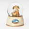 A nativity snow globe with a little Angel holding a lamb looking down over the baby Jesus.