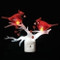 Night light that features a white branch and two red cardinals on the branch. 