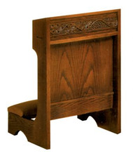 Square wooden structure with a soft pad for kneeling and an intricate pattern carved into the top.