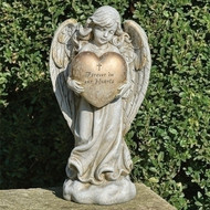 12.25"H  Memorial  Angel  Holding Heart. The inscription on the heart that the angel is holding says: " Forever in Our Hearts". Memorial Angel is made of a resin/stone mix. 
