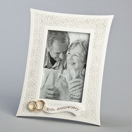 8.75"H  50th  Anniversary Lace Look Photo Frame adorned with two gold wedding rings and the words "50th Anniversary" attached on a banner across the bottom of the frame.  Frame holds 4" x 6" photo. Frame is made of a resin/stone mix and measures 8.75"H X 6.75"W X .75"L.