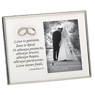 7"H white enameled wedding frame holds a 4X6 photo. Frame is white enamel with silver edging  around outer frame.  The verse 1 Corinthians 13 is printed on left side of frame under the double wedding bands. Materials: Iron