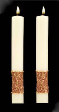 Two white candles side-by-side with a golden wrap around each at the bottom.