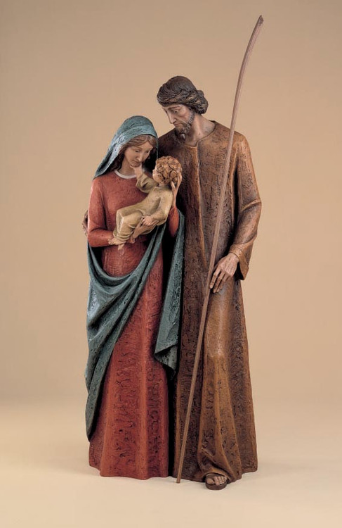 Colored sculpture of Virgin Mary being embraced by Saint Joseph, holding Child Jesus.
