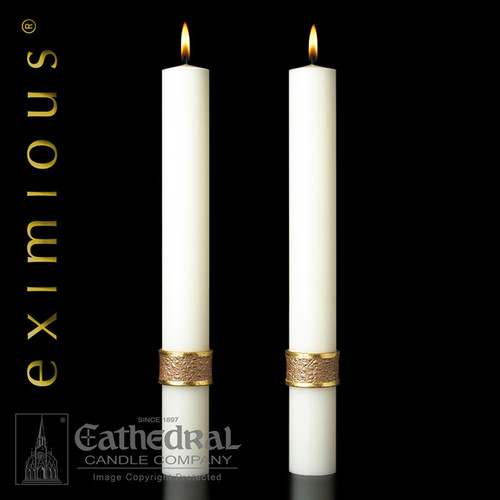 Image of two white tapered altar candles with a gold leaf band around the base.