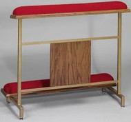 A red kneeling pad sits on top of two metal legs that are connected to another pad at chest height.