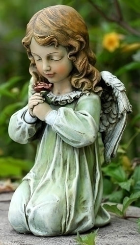 Statue of a little girl angel kneeling and holding a flower.