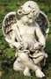 Garden statue of a cherub sitting on a stone and holding a kitten in his lap.