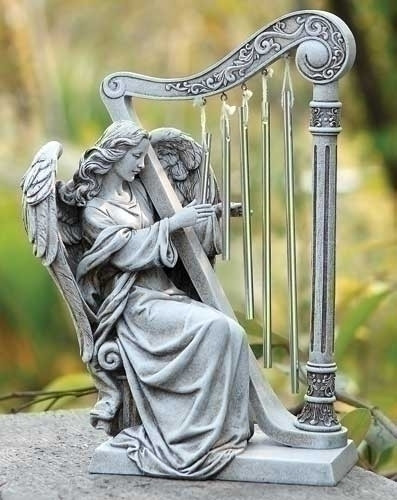An angel sitting and playing a harp made with wind chimes.