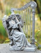 An angel sitting and playing a harp made with wind chimes.