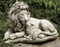 Statue of a lion and a lamb laying together.