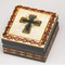 Preserve special mementos in the handsome cross design keepsake wood box from Poland! Handmade in Poland, the square cross design keepsake wood box measures 2.75 inches across and features a beautifully etched and dark colored cross in the center of the cover. This beautiful cross design keepsake wood box from Poland is made of seasoned linden wood, from the Tatra Mountain region of Poland. Beautifully etched in colored wood. Interior of box is lined with balsa wood. Also available is a Chalice Design Box (37856)  5" x 3.75, and a "Bible" Box (37858) 5" x 3.75'.
