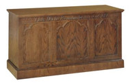 Communion table with closed back. Gothic detailing highlight this Communion Table. Detail includes inscription, "THIS DO IN REMEMBRANCE OF ME" on the front panel. The communion table is crafted using red oak and red oak veneer. Dimensions: 32" height, 60" width, 24" depth