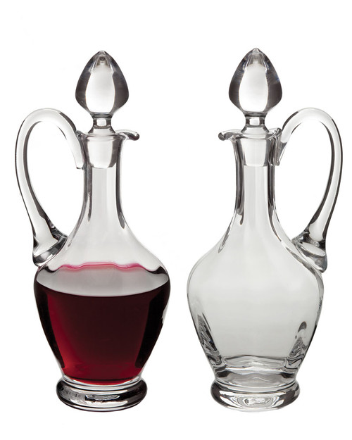 Image of two glass cruets with a red wine in one of them.