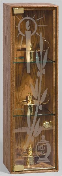 Ambry Cabinet Made of Oak in medium Oak finish with etched design on glass and a locking door. This design is wall mountable. Size : 8" W x  8"D x 27"H.