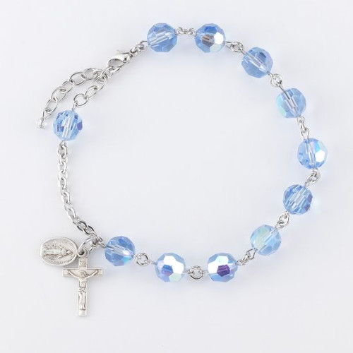 8mm Round Faceted Light Sapphire Swarovski Crystal Bead Rosary Bracelet. Sterling silver miraculous medal and crucifix with sterling silver or rhodium plated brass findings. Comes in a deluxe velour gift box. Made in the USA.