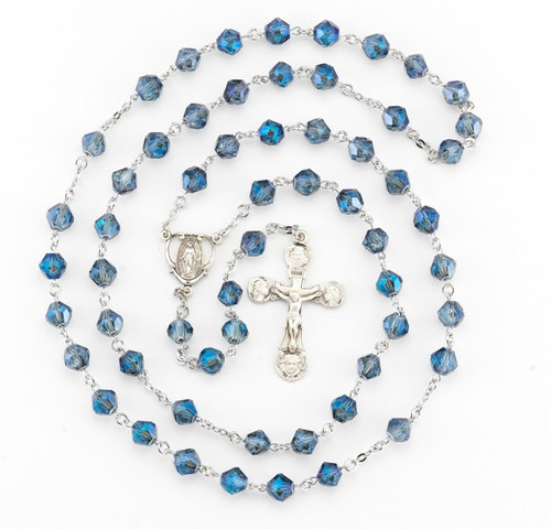 8MM Metalllic Sapphire tin cut crystal beads. rosary is made of Rhodium plated brass wires and chains with a sterling silver Miraculous Medal and 2" Crucifix.  This tin cut sapphire bead rosary comes in a deluxe velvet box. Rosary is made in the USA.