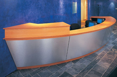 Product code: DR 01. Bespoke reception using combination of veneer wood and stainless steel vertical section. Specifically designed to fit within a defined space this reception enhances the space whereas a conventional unit may have been too deep or wide.