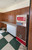 A nostalgic, retro-inspired breakroom, commercial space, or recreation room that captures a distinct mid-to-late 20th-century Americana vibe. The space leans heavily into classic vintage styling, combining mid-toned Spirit Birch wood wall paneling with a traditional checkered floor and a prominent piece of retro machinery.