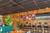 A vibrant, eclectic, and modern commercial hospitality space—such as a trendy restaurant, bar, or café—that masterfully blends mid-century warmth with bold, contemporary design accents. The room relies on the organic texture of full-wall Spirit Birch wood paneling.