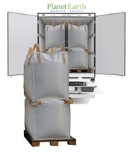 Two large white bulk totes stacked vertically on a wooden pallet in front of a delivery truck.
