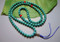 Turquoise 111 bead mala with three coral accents and knotted tassel. 