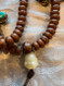 Old vintage bodhiseed mala with Buddha head close up detail