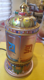 Love and compassion electric prayer wheel with Om Mani Padme Hum, side view with seed syllable mantra. 